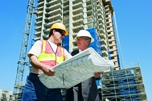stock-photo-18160637-multiracial-engineers-at-industrial-site-reading-plans